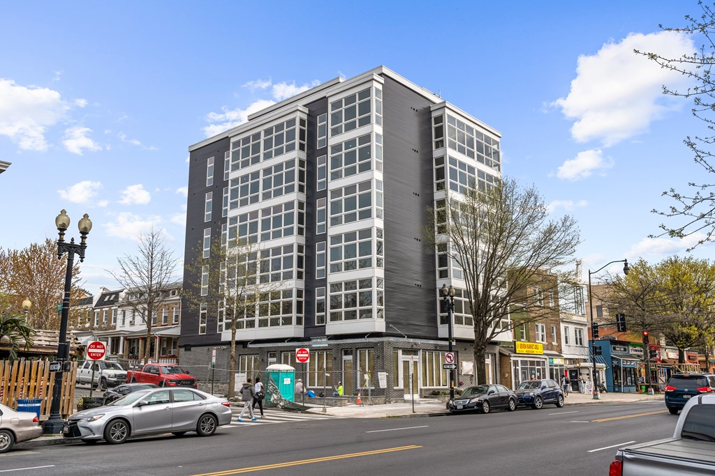 A silver car is parked on the side of the street.