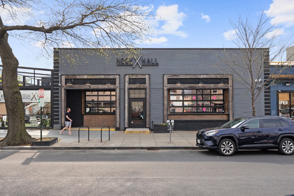 A car is parked in front of a building with a sign that says "Hall".