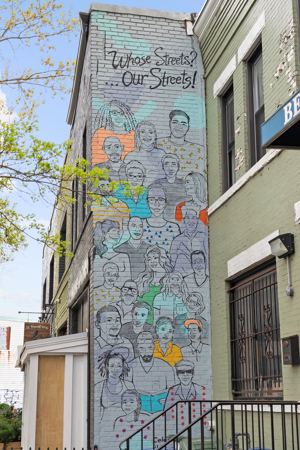 A mural on a building says "Whose Streets? Our Streets!".