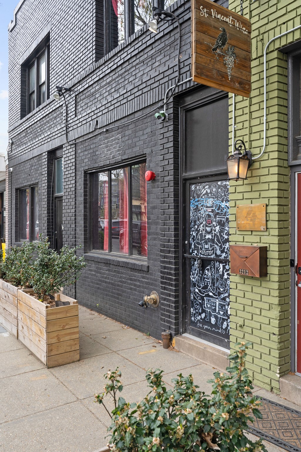 A black building with a green door and a sign that says St. Vincent Place.
