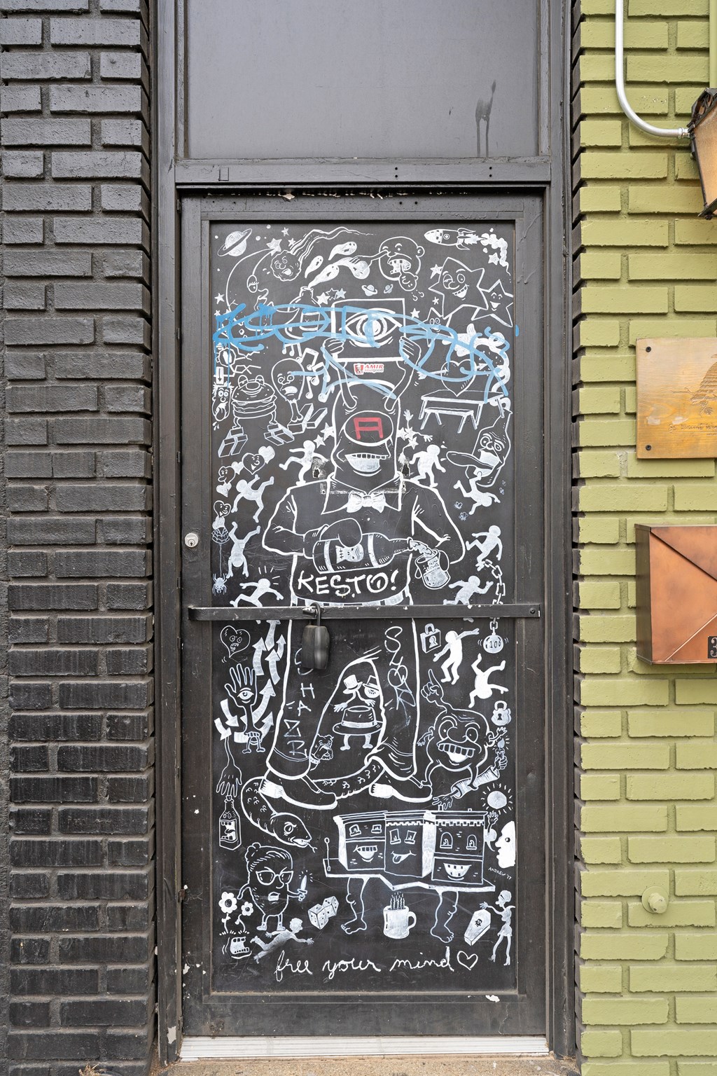 A door with a chalkboard and a drawing of a man with a beard and glasses.