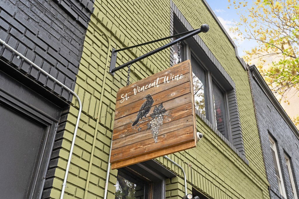 A sign for St. Vincent Wine hangs from a building.