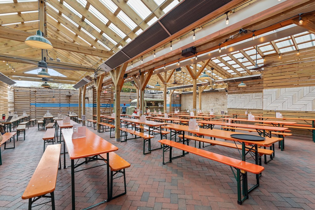 A large open-air restaurant with wooden tables and benches.