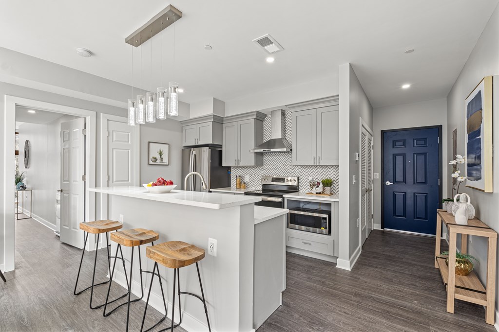 A kitchen with a white countertop and a blue door.