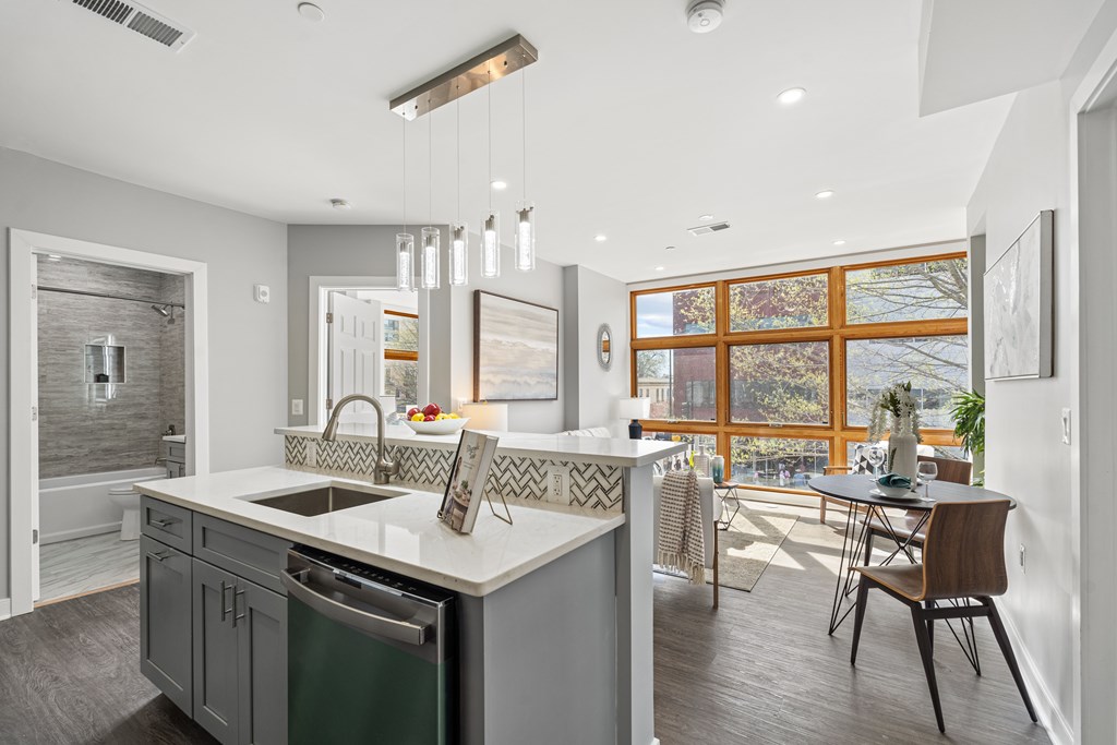 A modern kitchen with a large island and a dining table.