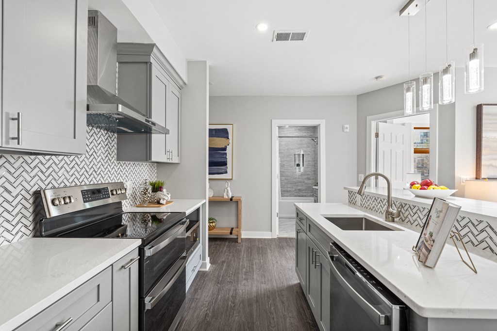 A modern kitchen with a black and white tiled backsplash.
