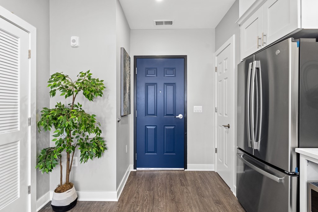 A blue door is in the middle of a hallway.
