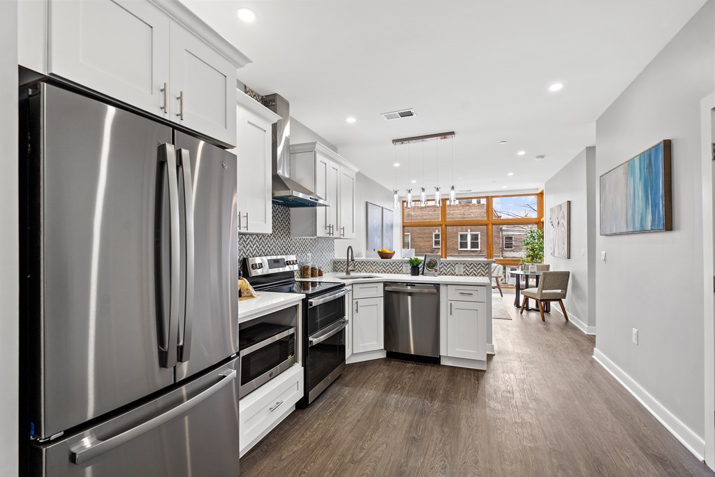 A modern kitchen with stainless steel appliances and white cabinets.