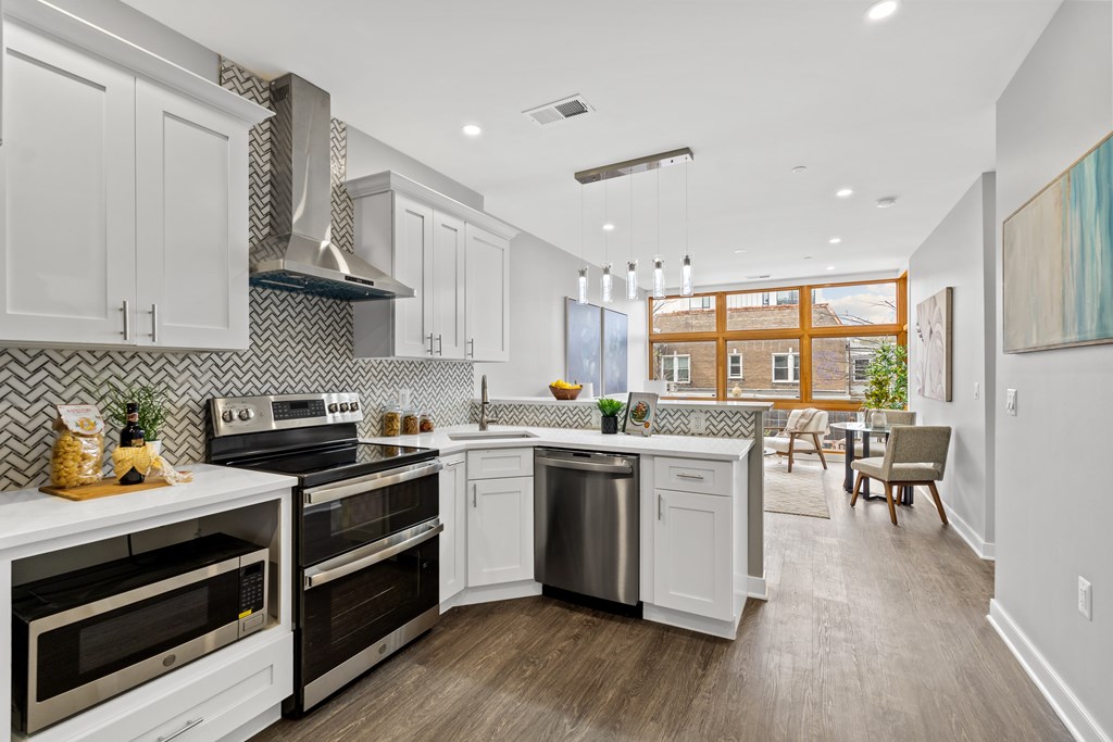 A modern kitchen with white cabinets and stainless steel appliances.