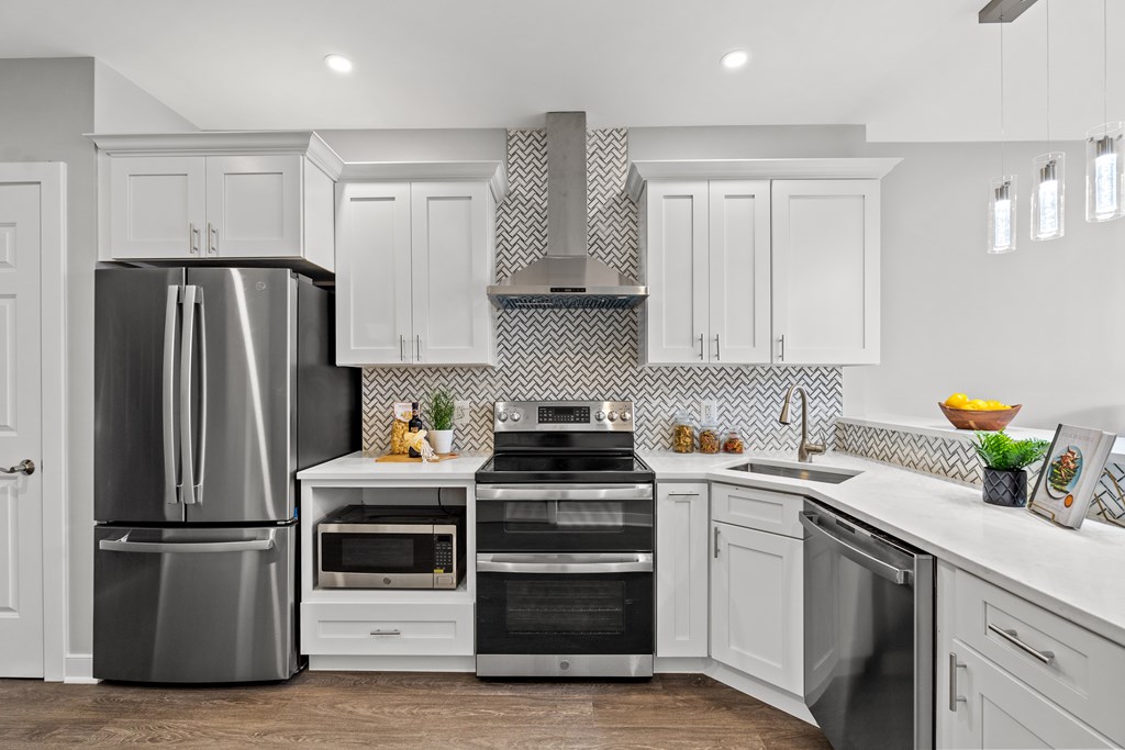 A modern kitchen with a stainless steel refrigerator, oven, and microwave.