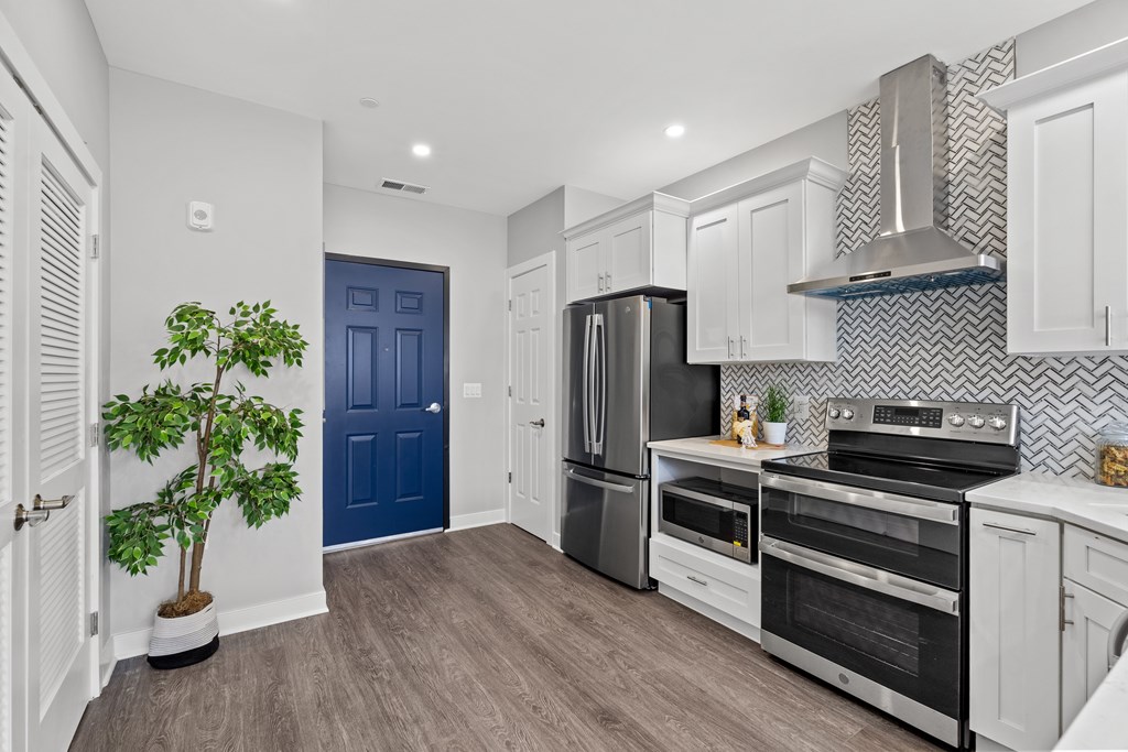 A kitchen with a blue door and stainless steel appliances.