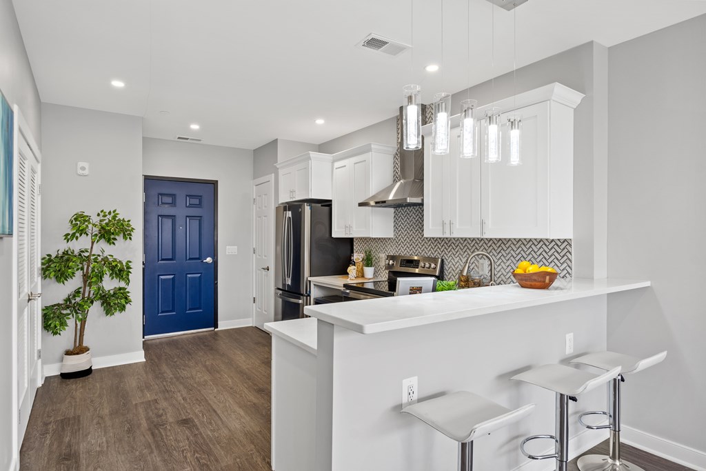 A kitchen with a blue door and white cabinets.