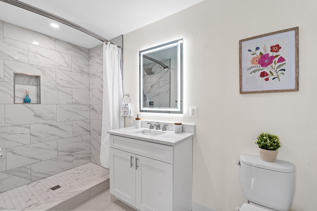 A bathroom with a white toilet and a white sink.