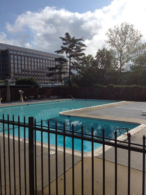 a large swimming pool with a black fence around it