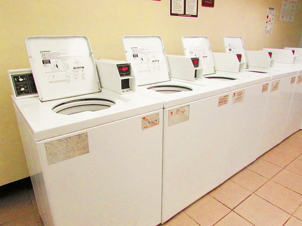 a row of washers and dryers in a laundry room