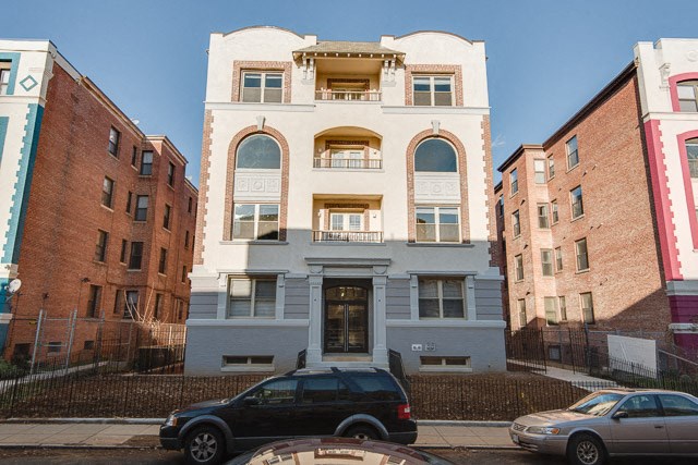a blue and white building with a car parked in front of it