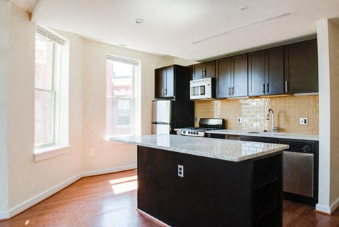 a kitchen with black cabinets and a white counter top