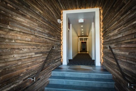 a hallway with wood paneling and a staircase
