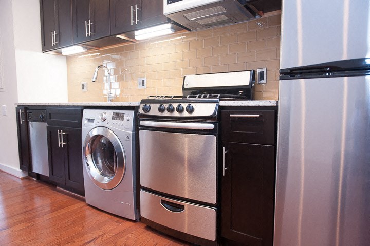 a kitchen with stainless steel appliances and black cabinets
