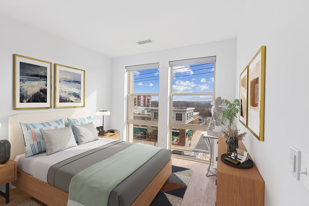 A bedroom with a large bed and a view of the city.