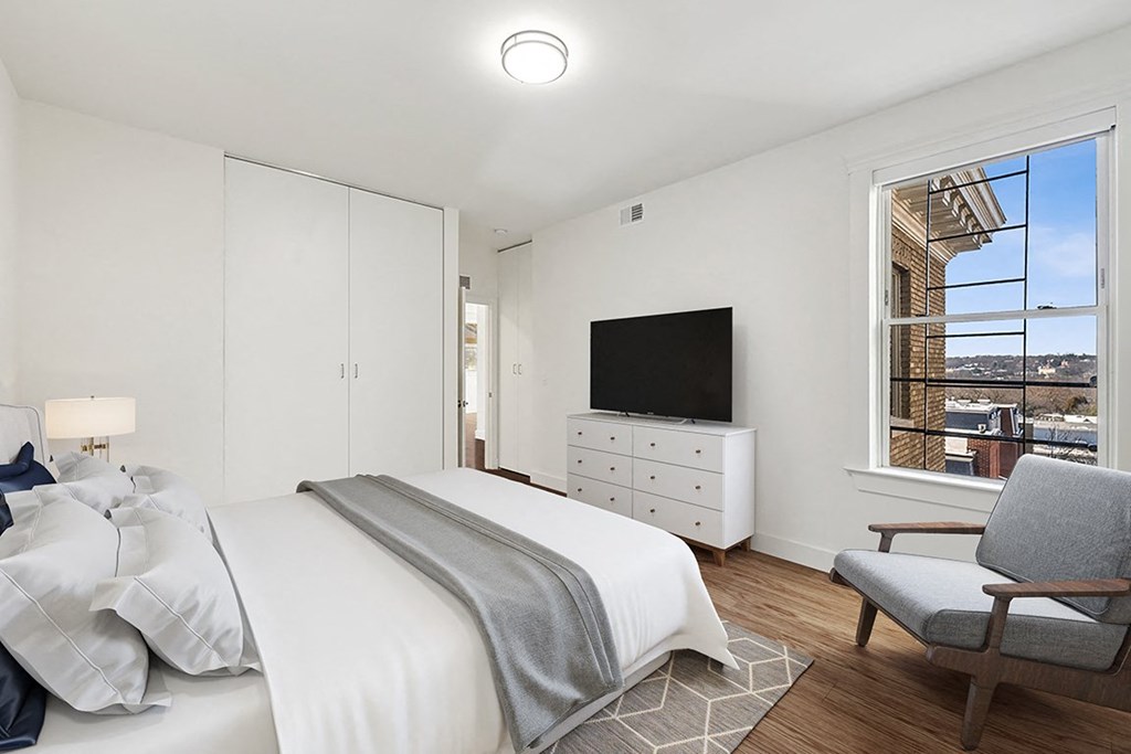 a bedroom with a bed and a large window