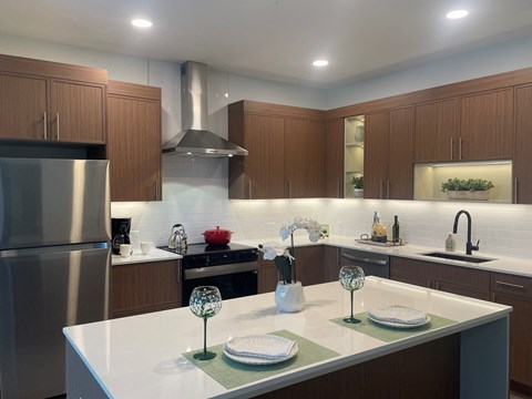 A modern kitchen with a stainless steel refrigerator and wooden cabinets.