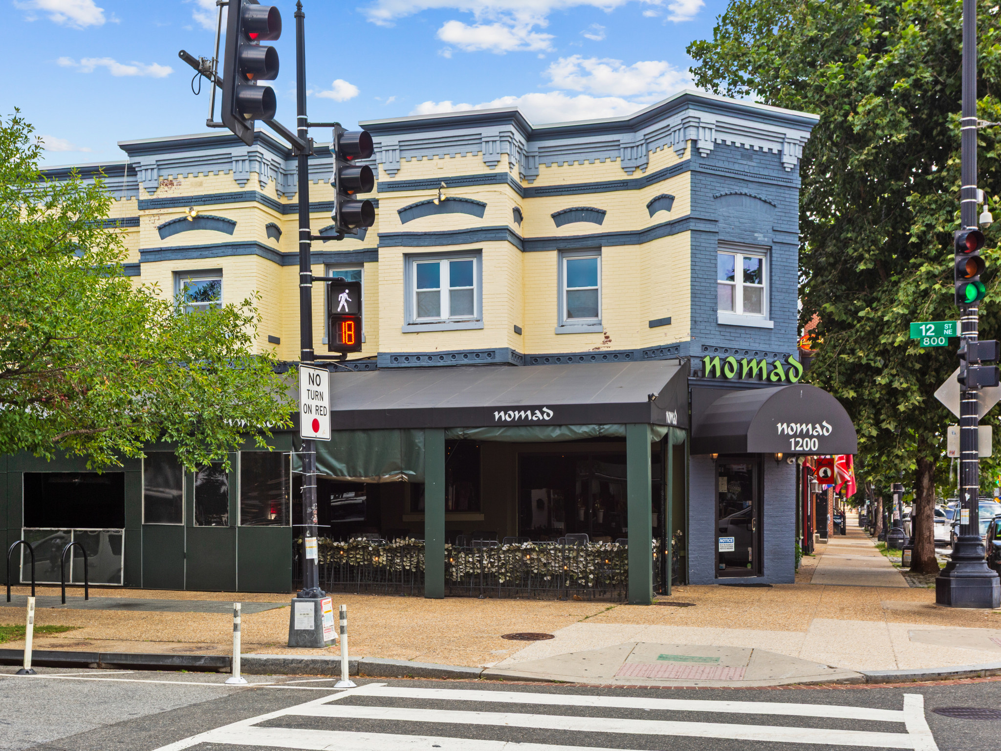 A street corner with a traffic light and a building with a sign that says "Homonad".