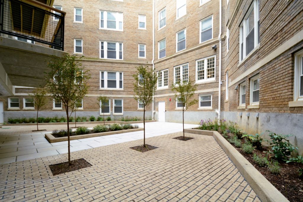 a courtyard with trees and a brick building
