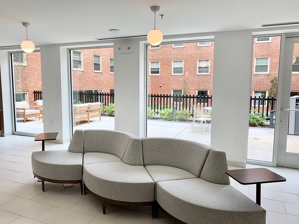 a seating area with a couch and tables in front of a window at Carver and Slowe Apartments, Washington Washington, DC
