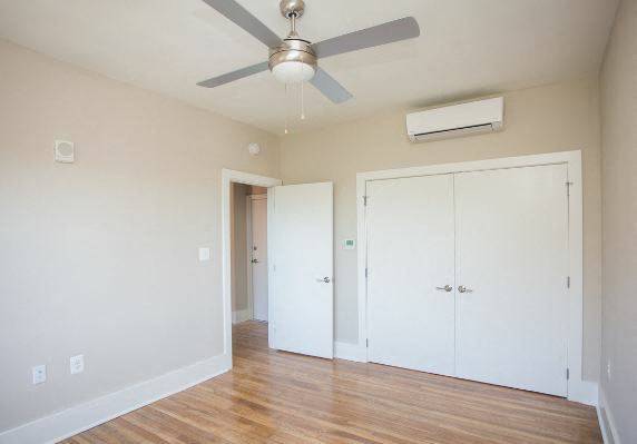an empty room with a ceiling fan and a door