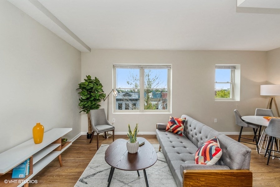 a living room with a couch and a coffee table in front of a window