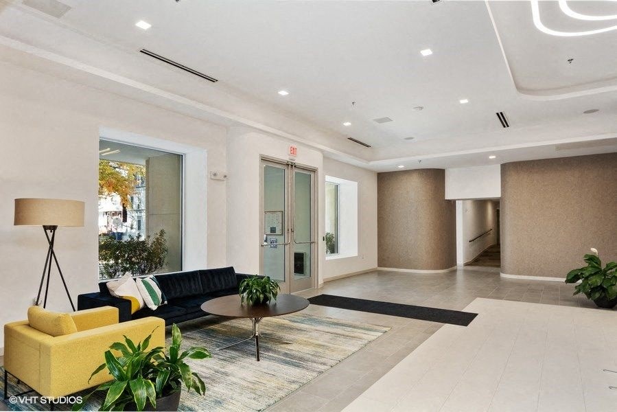 a lobby with a yellow couch and a coffee table at Carver and Slowe Apartments, Washington Washington, DC