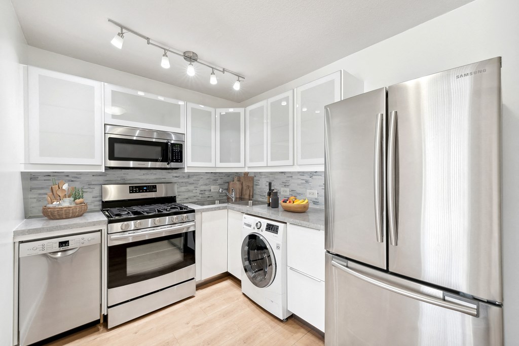a kitchen with stainless steel appliances and white cabinets