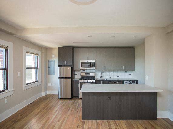 a kitchen with a stove a refrigerator and a microwave