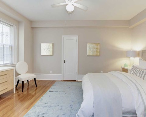 a bedroom with a white bed and a ceiling fan