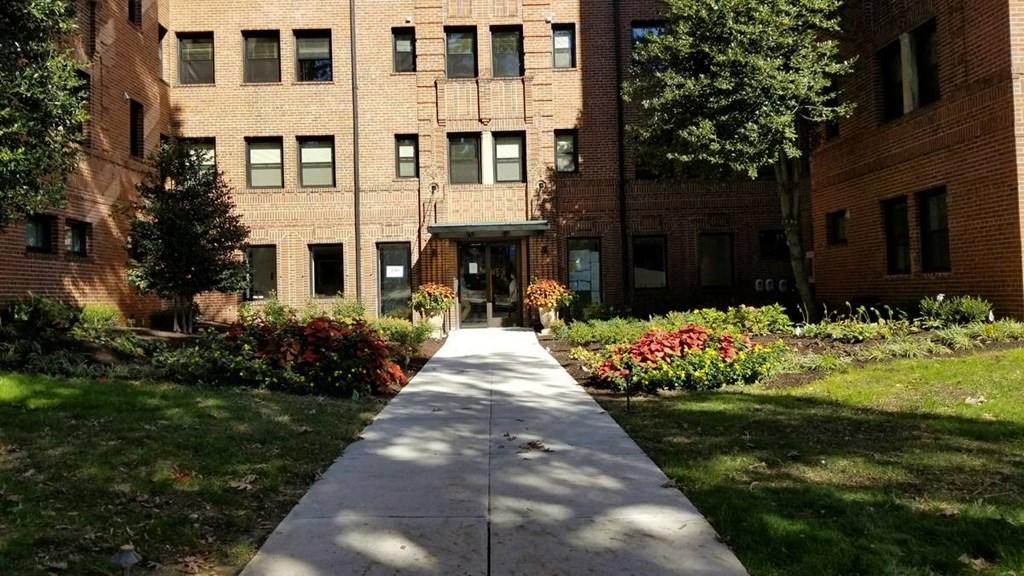 a large brick building with a sidewalk in front of it