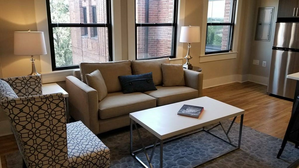 a living room with a couch coffee table and a refrigerator
