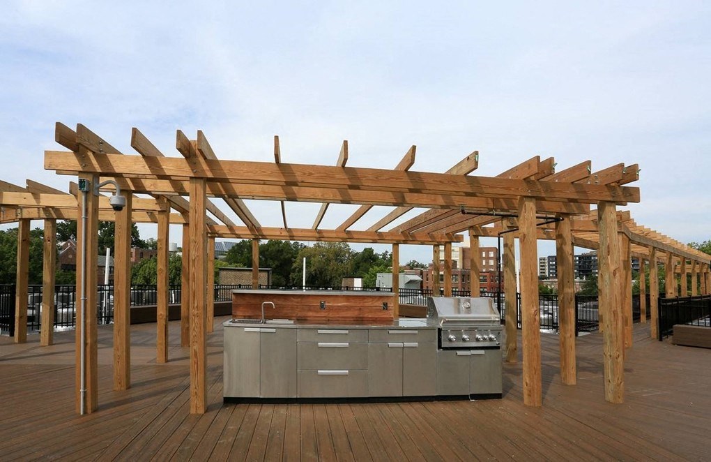 an outdoor kitchen with a pergola on top of it
