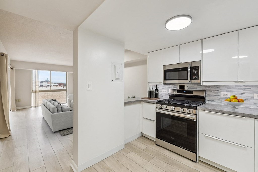a kitchen with white cabinets and a stove and a microwave