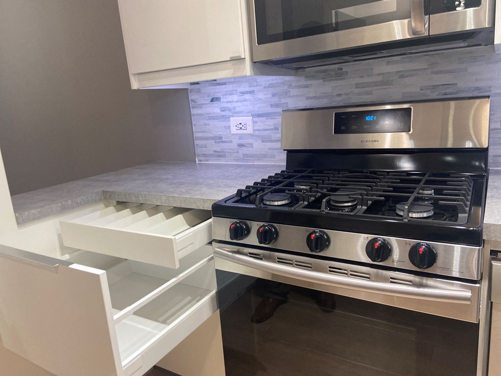 a kitchen with a stove top oven next to a microwave