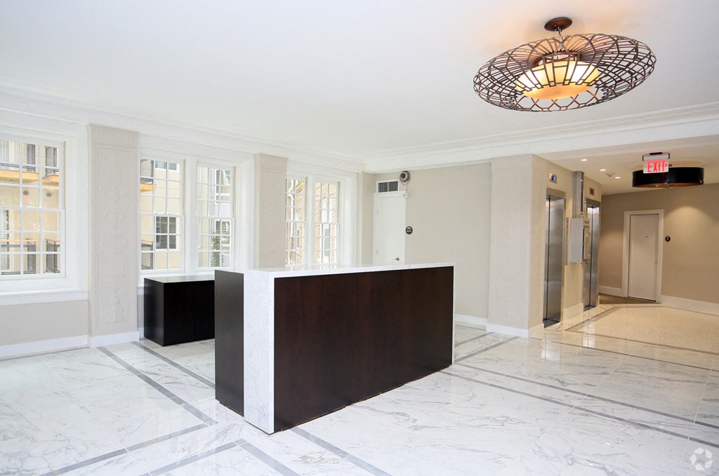 a large lobby with a reception desk and a large chandelier