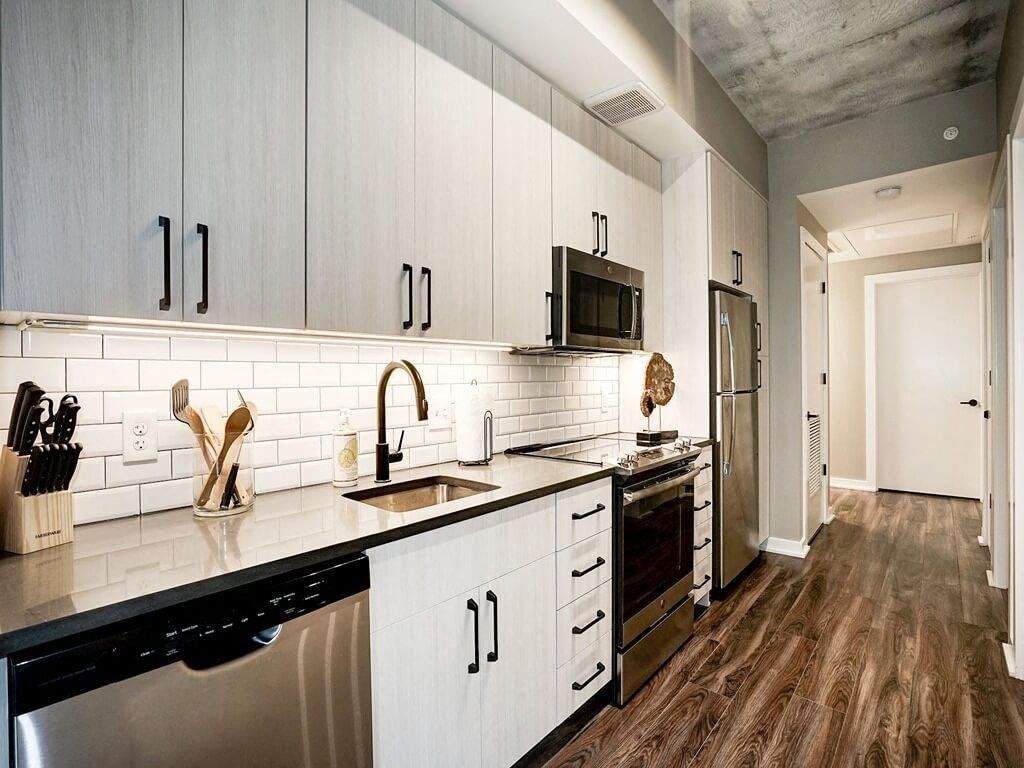 a kitchen with white cabinets and a sink and a refrigerator