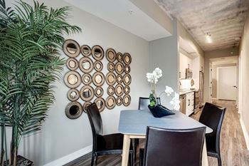 a dining room with a table and chairs and a plant at Coda on H Apartments, District of Columbia