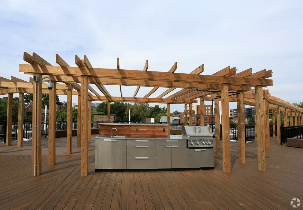 an outdoor kitchen with a wooden pergola
