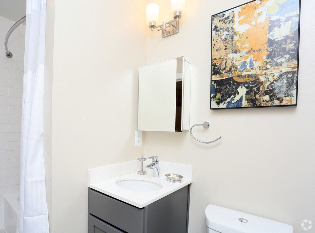 a bathroom with a white sink and toilet and a white shower curtain