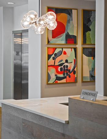 a view of the reception desk with three paintings on the wall