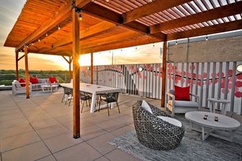 a patio with a wooden roof and chairs and tables