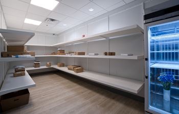 a room with empty shelves and a vase of flowers