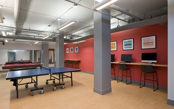 a gaming room with a ping pong table and computers