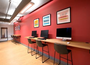 a row of computers sitting on top of a wooden desk
